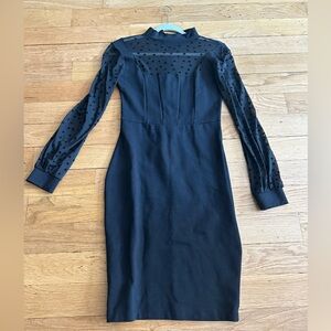 A sophisticated black dress adorned with a sheer mesh top. Size M